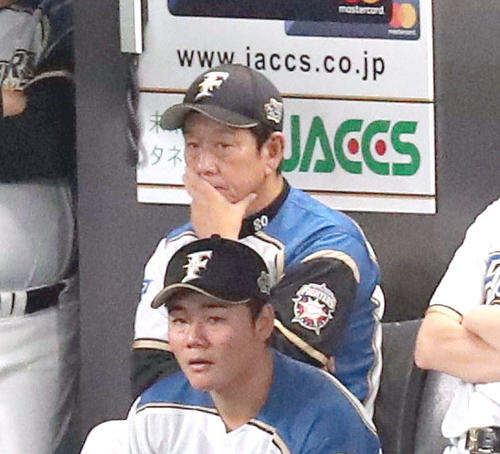 追加点を許し、ベンチで険しい表情を見せる日本ハム栗山監督（奥）。手前は清宮（撮影・佐藤翔太）
