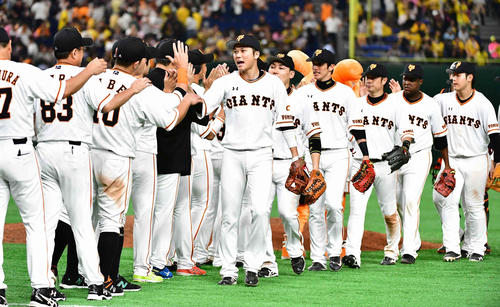 巨人対阪神　阪神を下し、巨人坂本勇（中央）は歓喜のナインとハイタッチ（撮影・小沢裕）