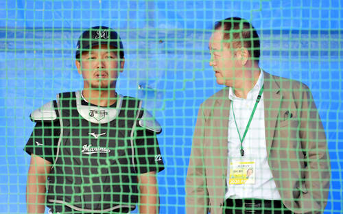 ブルペンで佐々木朗のボールを受けたロッテ田村（左）と話す田村藤夫氏（撮影・滝沢徹郎）