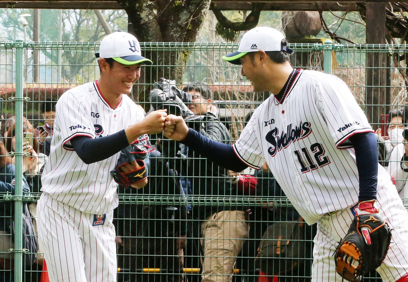 初ブルペンで22球を投げ、受けた小山田ブルペン捕手（右）と笑顔でグータッチを交わすヤクルト奥川（撮影・菊川光一）