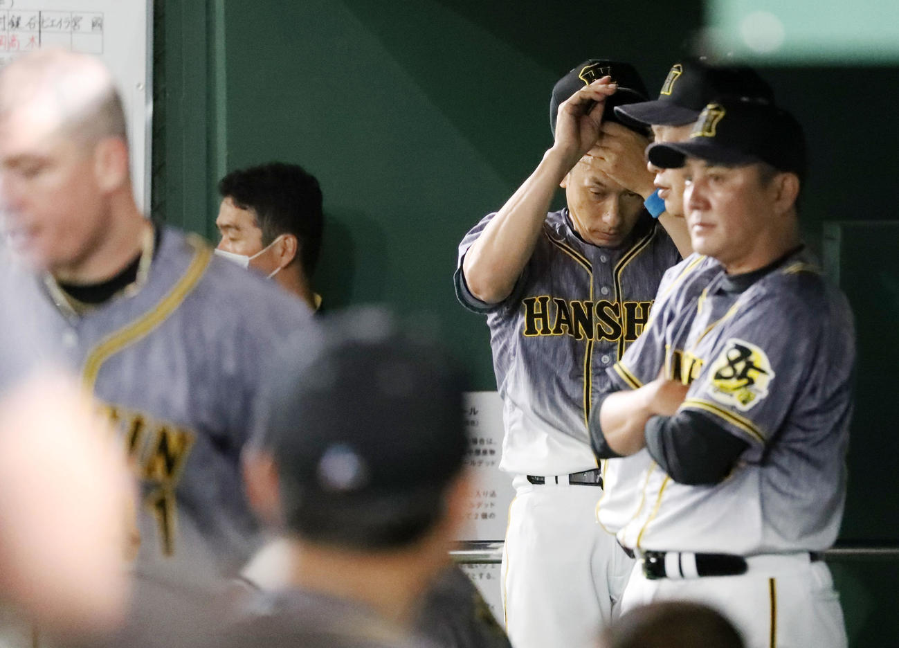 巨人対阪神　9回表、ベンチで帽子をとる矢野監督、左はボーア（撮影・加藤哉）
