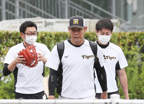小雨の中、室内練習場へ向かう阪神原口（中央）（撮影・前田充）
