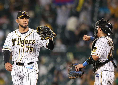 ロベルト・スアレス（左）は試合を締め捕手梅野隆太郎とグータッチする（撮影・上山淳一）
