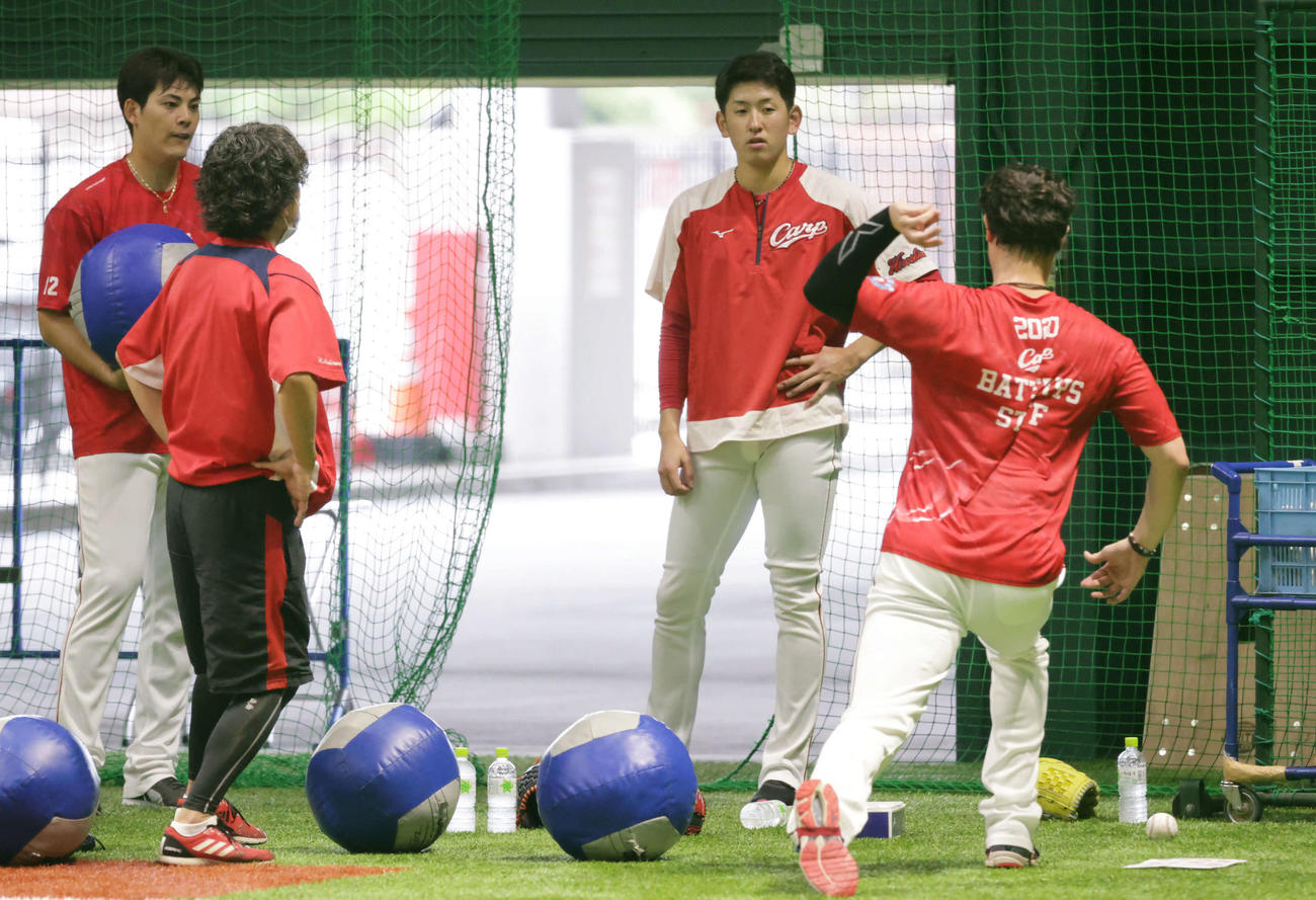 プロ野球広島　投手指名練習　K・ジョンソン（右）からアドバイスを受ける遠藤（右から2人目）。左は九里（撮影・加藤孝規）