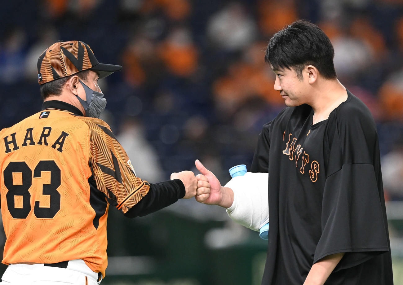 巨人対DeNA　開幕から13連勝でプロ通算100勝目となった巨人菅野（右）は原監督とグータッチ（撮影・山崎安昭）
