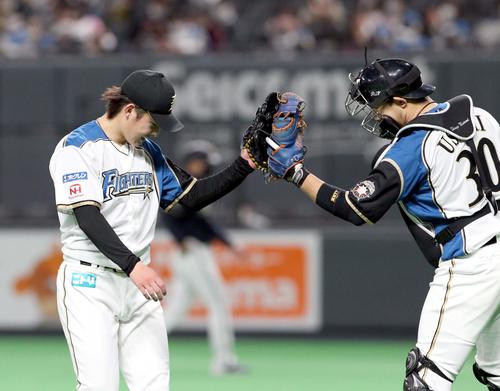 日本ハム対オリックス　5回表を無失点に抑えグータッチを交わしながらベンチに戻る日本ハム吉田輝（左）と宇佐見（撮影・佐藤翔太）