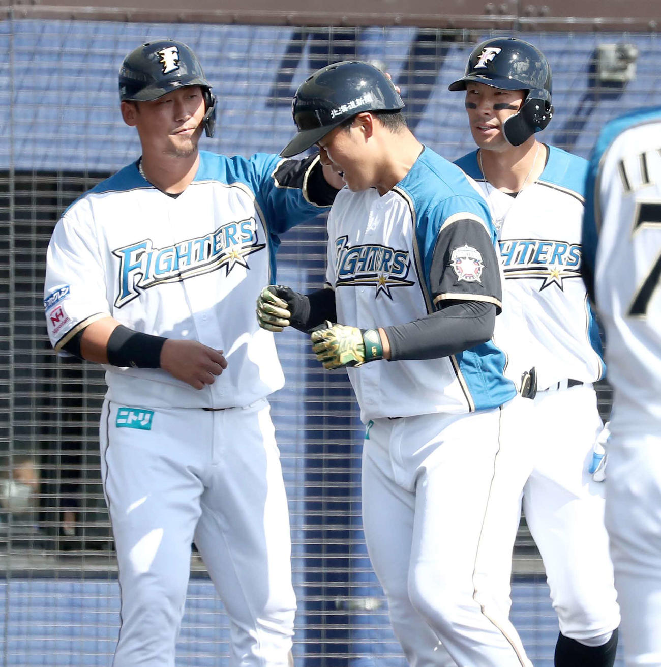 練習試合　日本ハム対中日　4回裏日本ハム1死一、二塁、右越え3点本塁打を放った清宮（中央）は中田（左）に頭をたたかれ迎えられる（撮影・黒川智章）