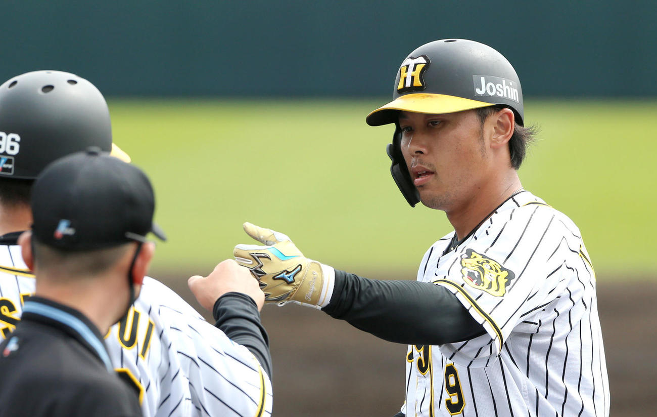 阪神対DeNA 2回裏阪神無死、高山（右）は中前打を放ち筒井コーチとグータッチ（撮影・上山淳一）