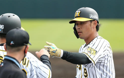 阪神対DeNA 2回裏阪神無死、高山（右）は中前打を放ち筒井コーチとグータッチ（撮影・上山淳一）