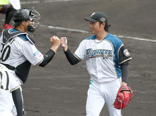 練習試合　日本ハム対広島　2回表、無失点に抑え宇佐見（左）とタッチする伊藤（撮影・黒川智章）