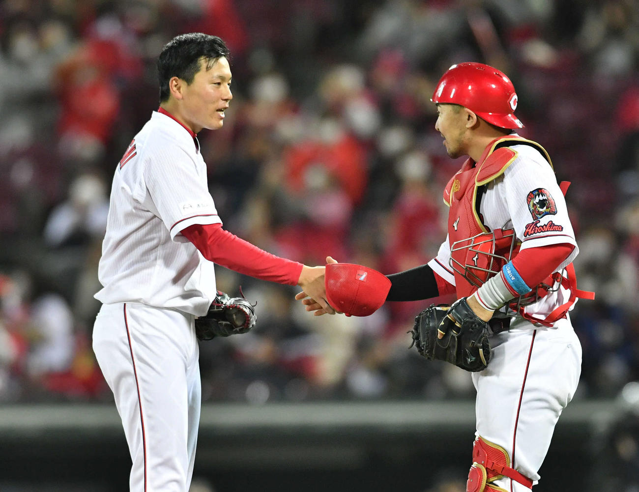 広島対阪神　9回表阪神の攻撃を3者凡退に抑え試合終了し、会沢翼（右）と握手を交わす栗林良吏（撮影・岩下翔太）