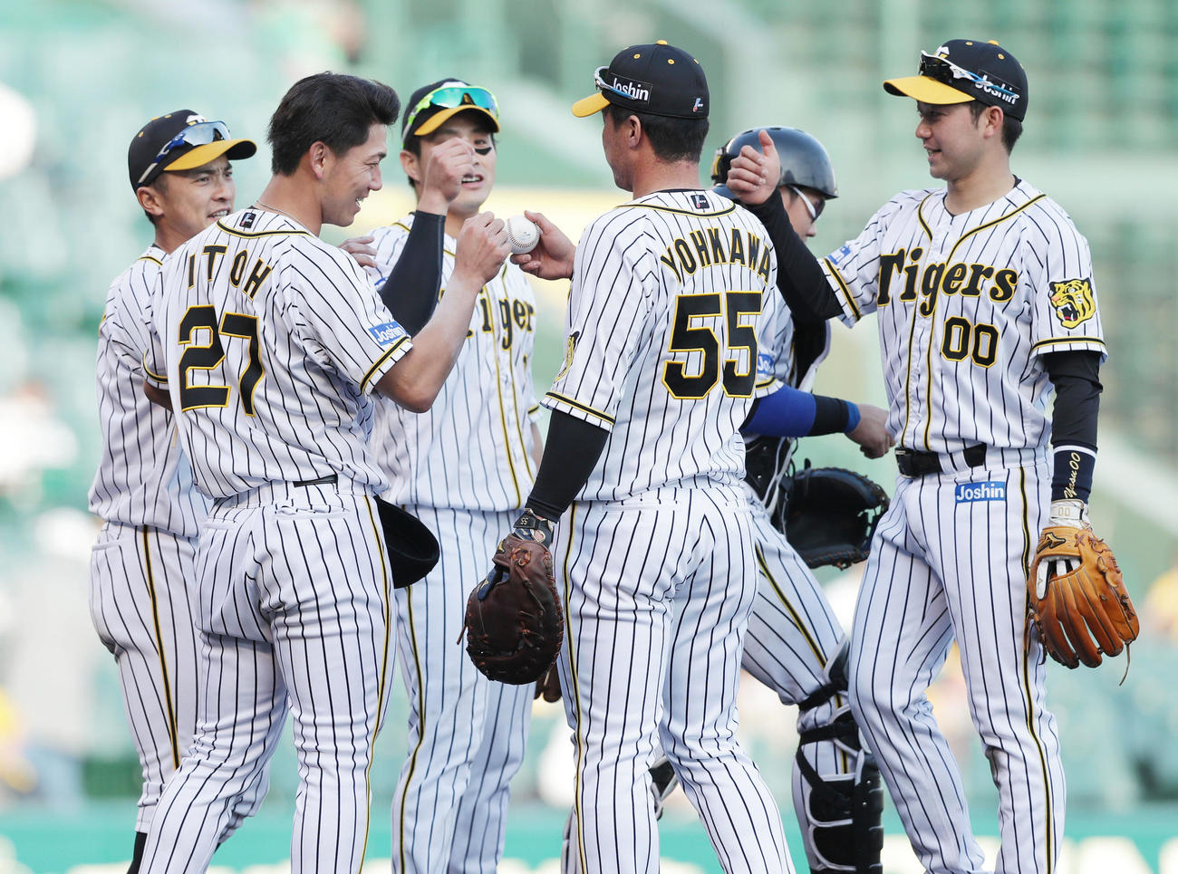 阪神対DeNA　プロ初完投勝利を挙げた伊藤将（左から2人目）は陽川（中央）から勝利球を受け取る（撮影・前田充）
