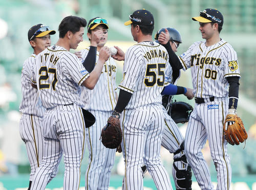 阪神対DeNA　プロ初完投勝利を挙げた伊藤将（左から2人目）は陽川（中央）から勝利球を受け取る（撮影・前田充）