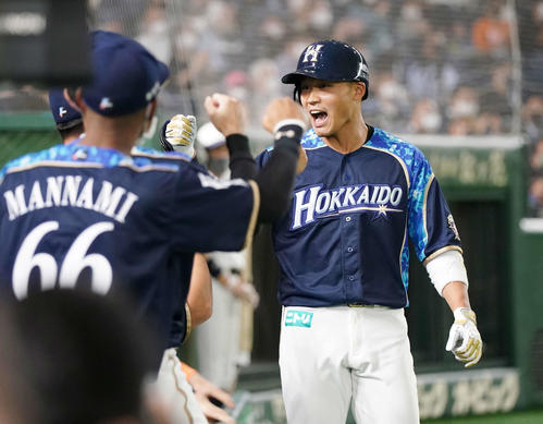 日本ハム対オリックス　2回裏日本ハム1死、先制の右越えソロ本塁打を放った王柏融は笑顔でナインとタッチを交わす（撮影・鈴木みどり）