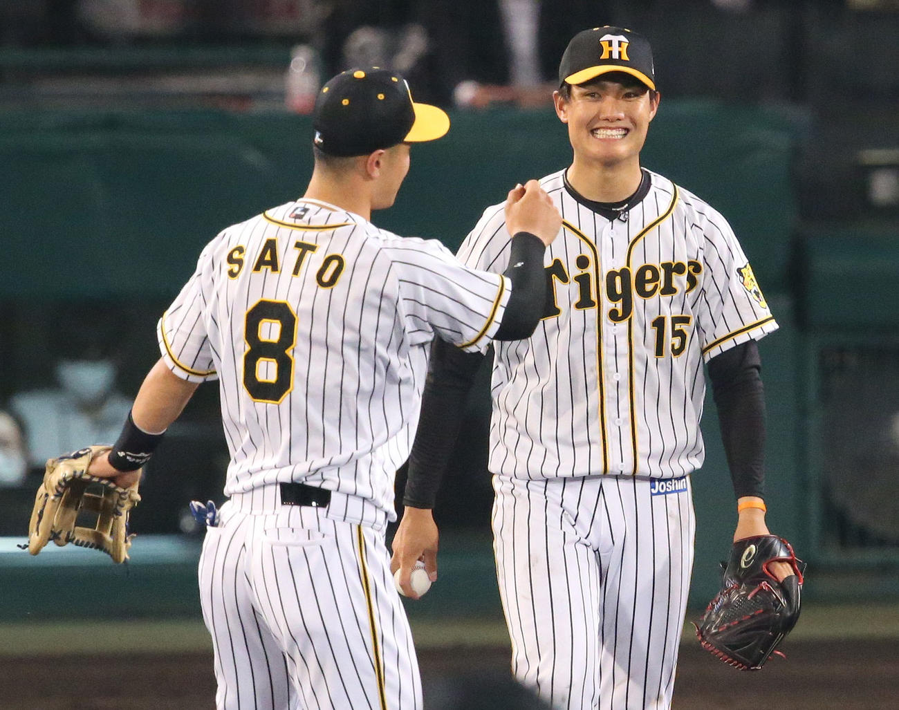 阪神対ヤクルト　5回表ヤクルト1死、西純（右）はサンタナを三ゴロに仕留め三塁手佐藤輝に笑顔を見せる（撮影・上山淳一）