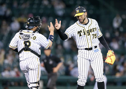 阪神対オリックス　スアレス試合を締め笑顔で捕手梅野とポーズを決める（撮影・上山淳一）
