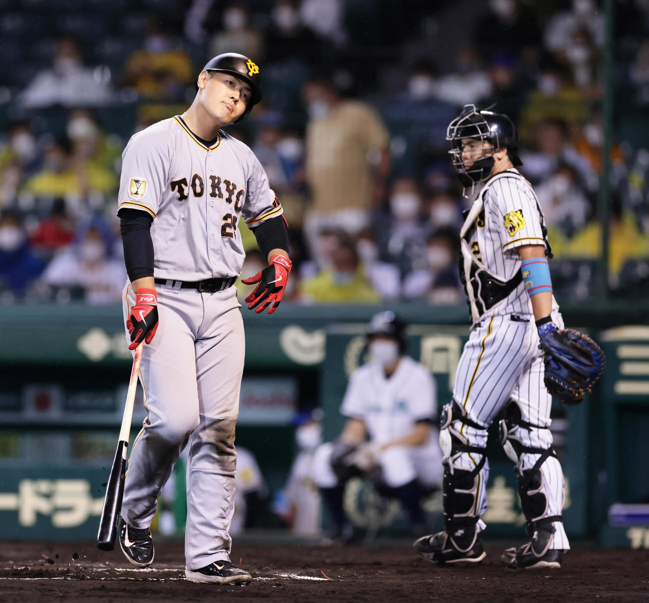 阪神対巨人　7回表巨人1死一塁、見逃し三振に倒れ首をかしげる岡本和。右は阪神捕手梅野（撮影・足立雅史）