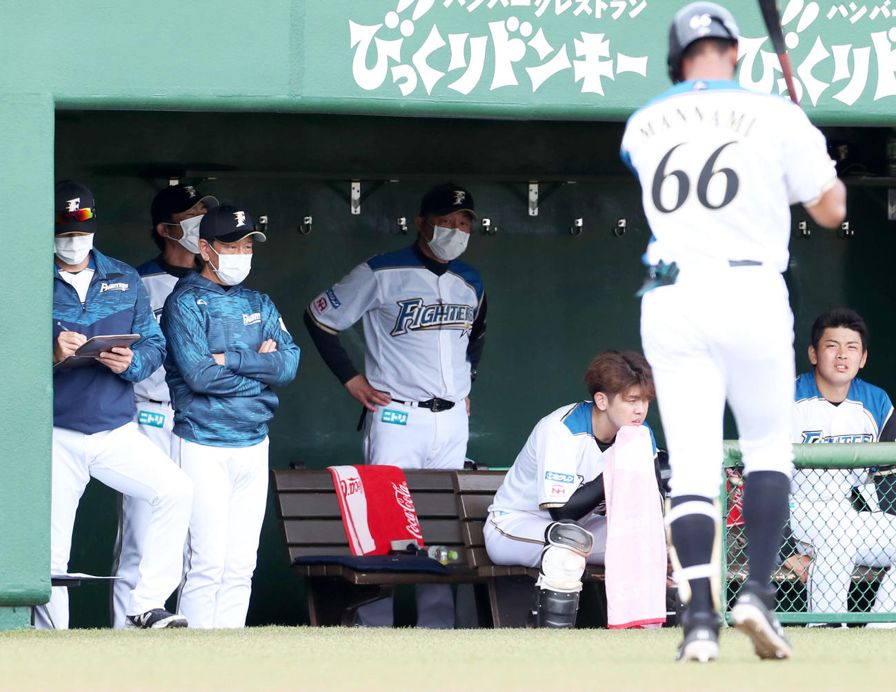 ベンチで険しい表情の日本ハム栗山監督（左から2人目）。右手前は三振に終わりベンチに戻る万波（撮影・佐藤翔太）