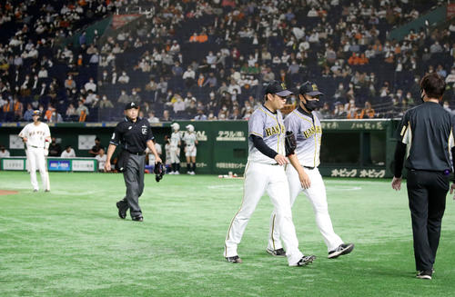 巨人対阪神　2回裏巨人2死三塁、西勇は自らベンチへ手を挙げてマウンドから歩み出し降板する。右は福原コーチ（撮影・加藤哉）