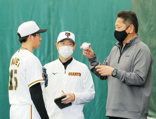 ブルペンで佐々木氏（右）から握りのレクチャーを受ける大勢（撮影・河田真司）