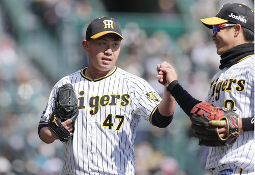 阪神対楽天　2回表の楽天打線を抑え、木浪（右）とグータッチを交わしてベンチへ戻る桐敷（撮影・前田充）