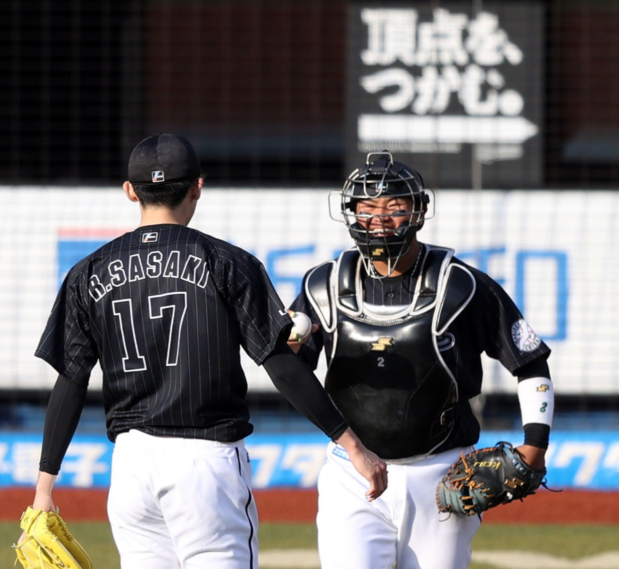 9回表オリックス2死、杉本を空振り三振に仕留め、完全試合を達成したロッテ佐々木朗（手前）にウイニングボールを届ける松川（撮影・狩俣裕三）