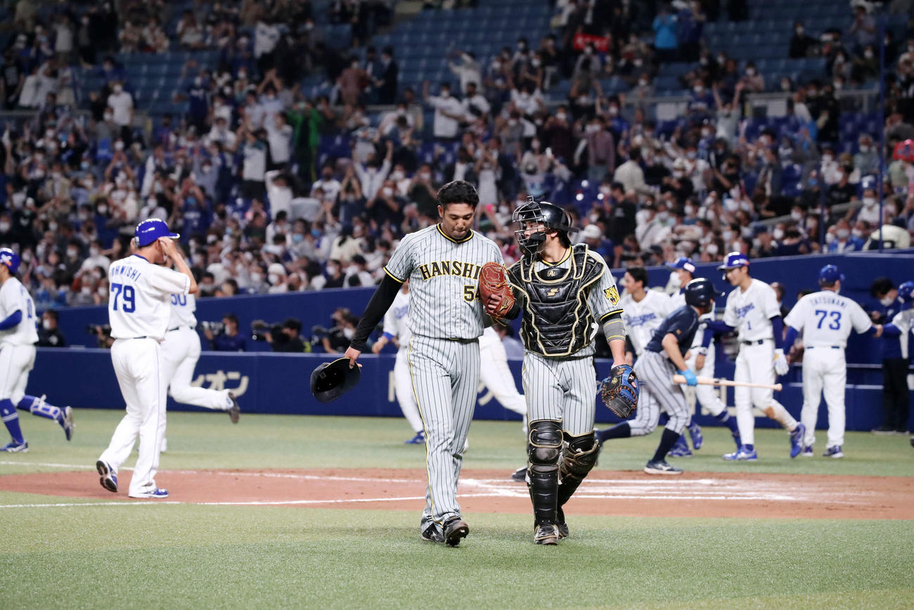 中日対阪神　10回裏中日1死一、二塁、加治屋（中央左）は大島に右中間を破るサヨナラ適時打を浴び、捕手梅野とベンチへ引き揚げる（撮影・加藤哉）