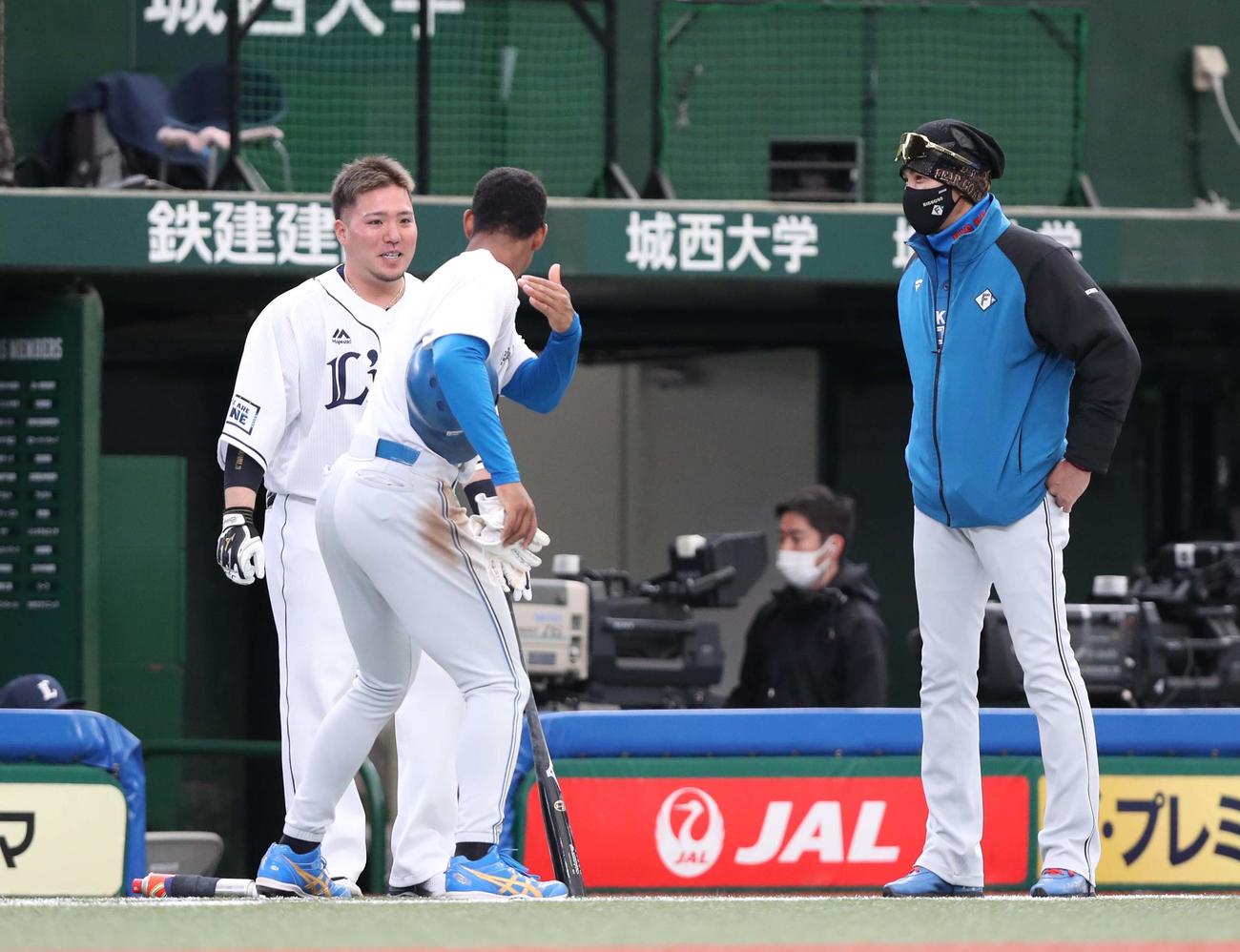 西武対日本ハム　試合前、新庄監督（右）に呼ばれ、山川（左）から打撃指導を受ける万波（撮影・黒川智章）