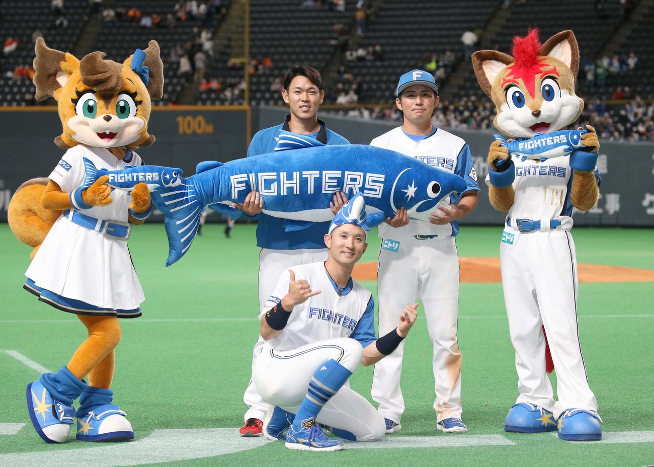 日本ハム対巨人　試合後、「しゃけまる」を持ち笑顔の左から根本、杉谷、上川畑（撮影・黒川智章）