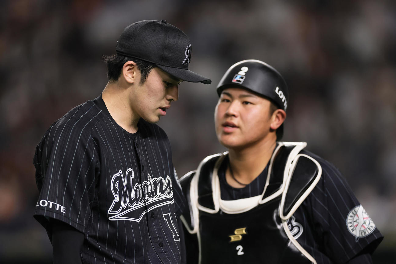 巨人対ロッテ　厳しい表情でベンチに戻るロッテの佐々木朗（左）と松川（撮影・足立雅史）