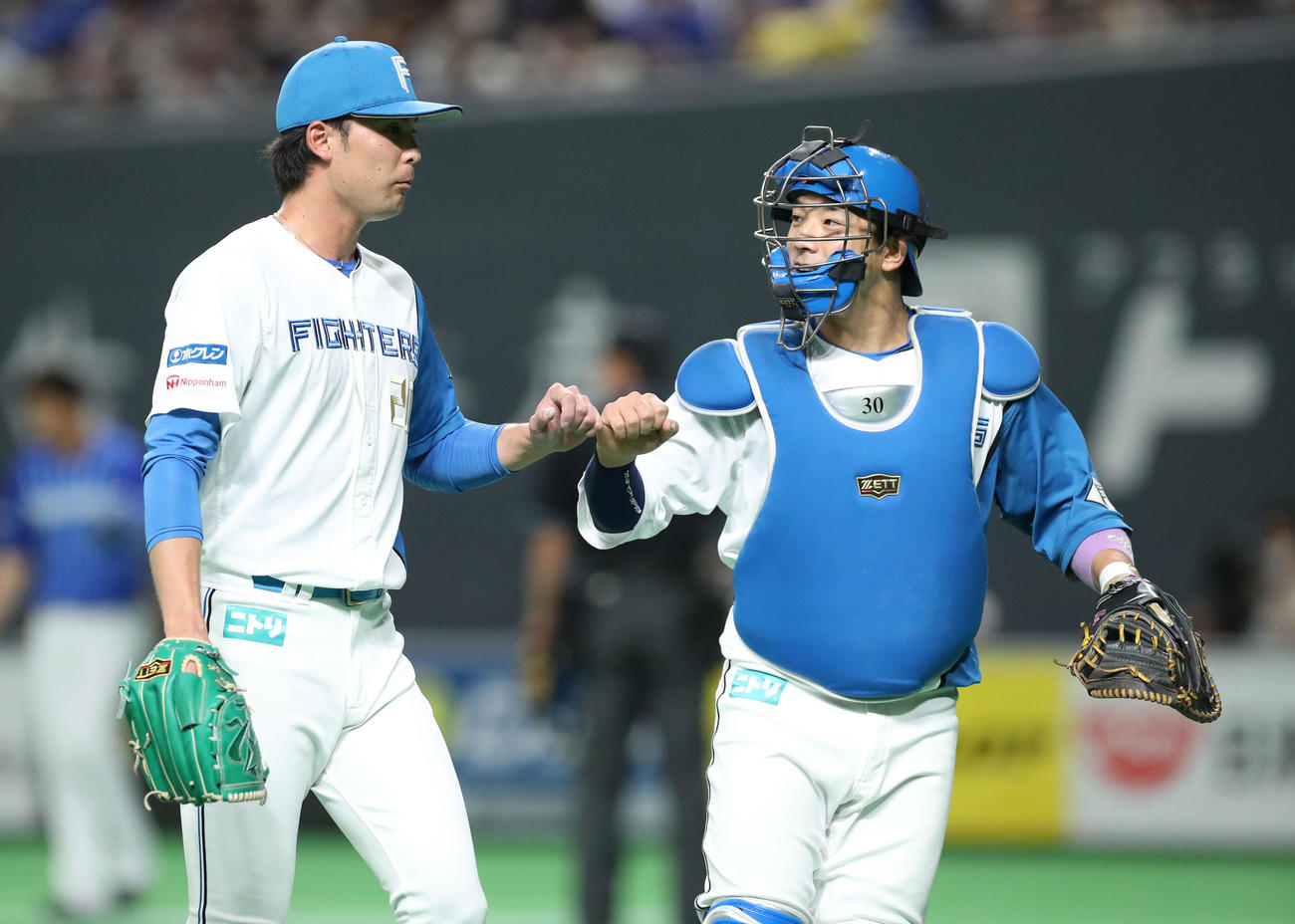 日本ハム対DeNA 1回表を無失点に抑えグータッチを交わしながらベンチに戻る日本ハム上原（左）と宇佐見（撮影・佐藤翔太）