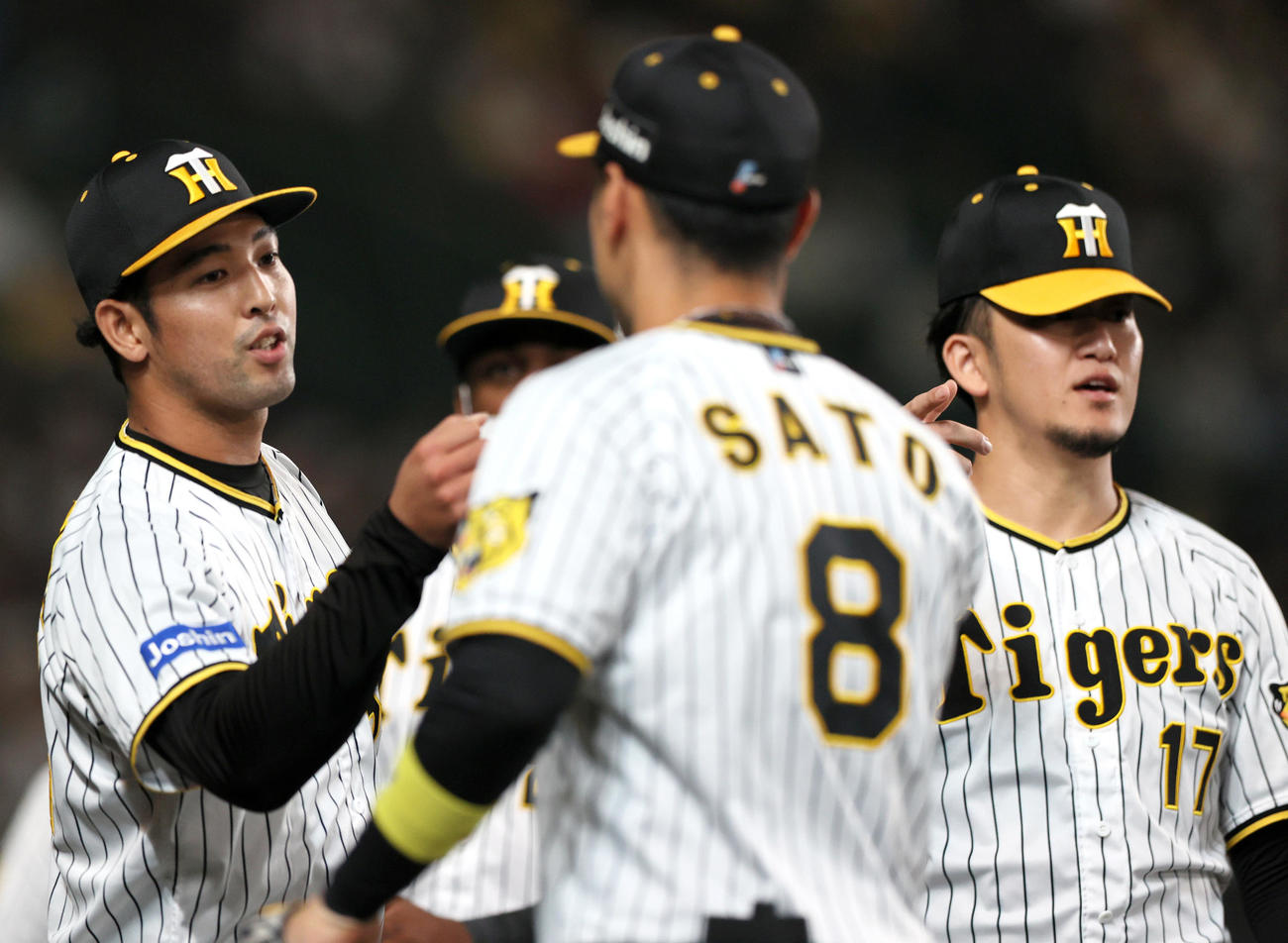 阪神対DeNA 7回途中で登板の阪神加治屋（左）は後続を抑えベンチ前でナインを出迎える。右は岩貞（撮影・上山淳一）