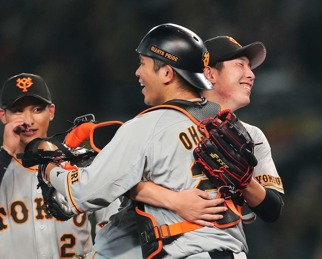阪神対巨人　プロ初完封勝利を収めた戸郷は大城（手前）と抱き合い喜ぶ。左は吉川（撮影・河田真司）