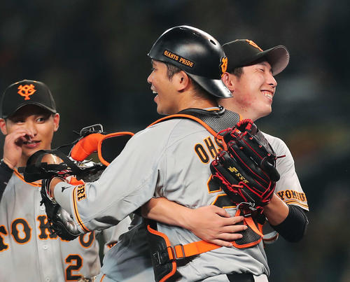 阪神対巨人　プロ初完封勝利を収めた戸郷は大城（手前）と抱き合い喜ぶ。左は吉川（撮影・河田真司）