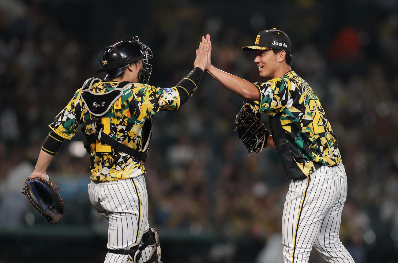 阪神対巨人　完封勝利を挙げ、阪神梅野（左）とタッチを交わす伊藤将（撮影・前田充）
