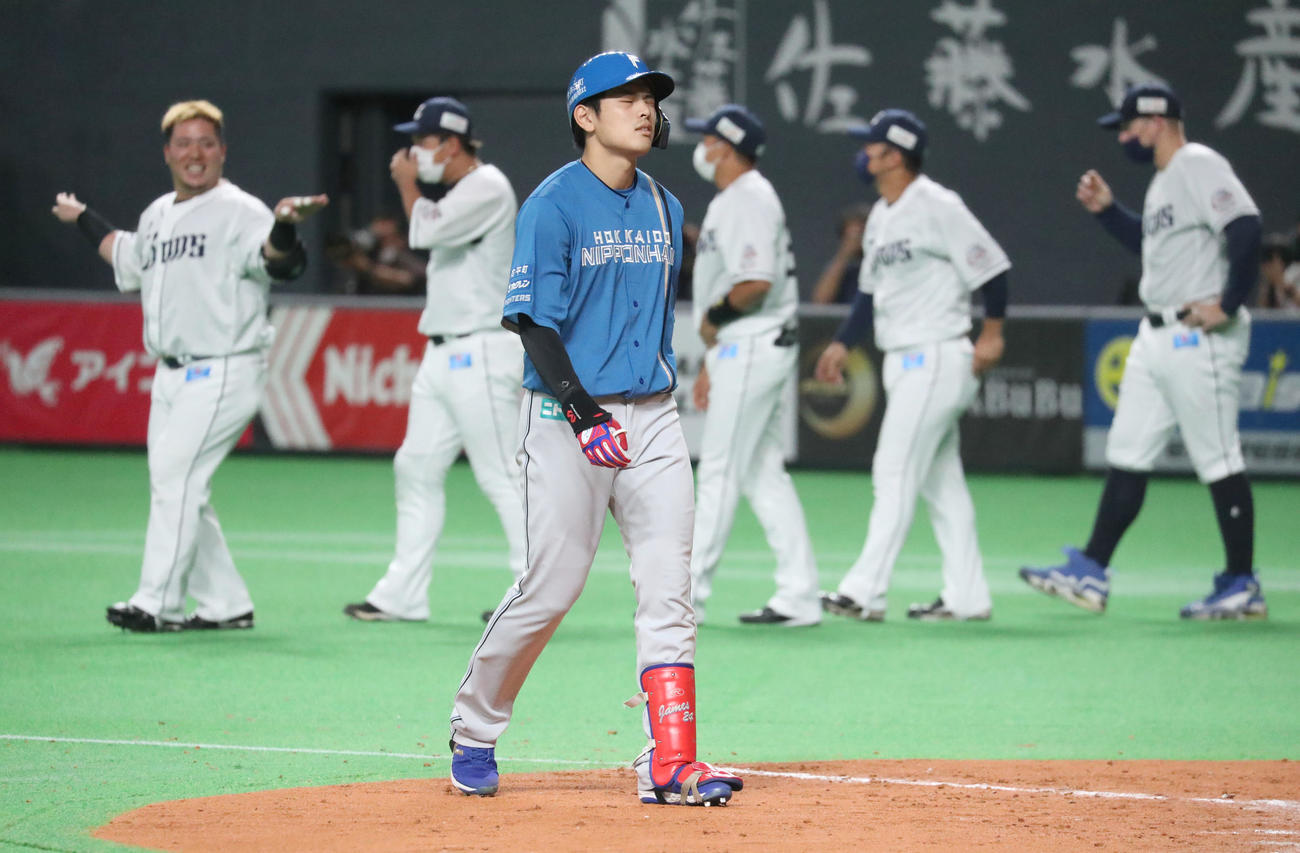 日本ハム対西武　9回裏日本ハム2死満塁、野村は右飛に終わり悔しそうな表情でベンチに戻る。左後方は笑顔でおどける山川（撮影・佐藤翔太）