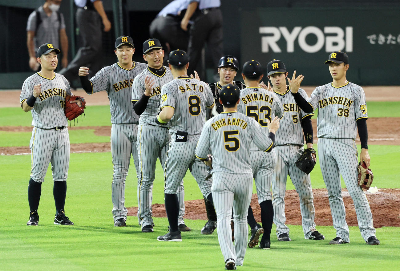 広島対阪神　マツダスタジアムで初勝利し、タッチを交わす岩崎（左から3人目）と梅野（同5人目）ら阪神ナイン（撮影・加藤哉）