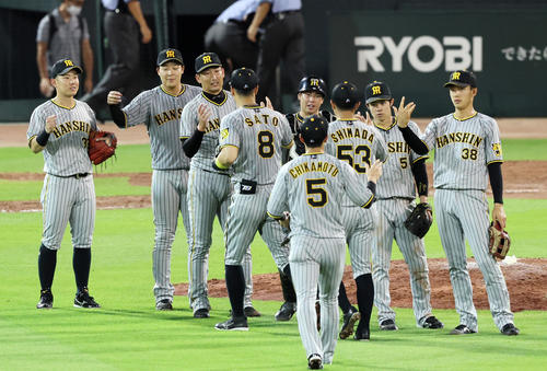 広島対阪神　マツダスタジアムで初勝利し、タッチを交わす岩崎（左から3人目）と梅野（同5人目）ら阪神ナイン（撮影・加藤哉）