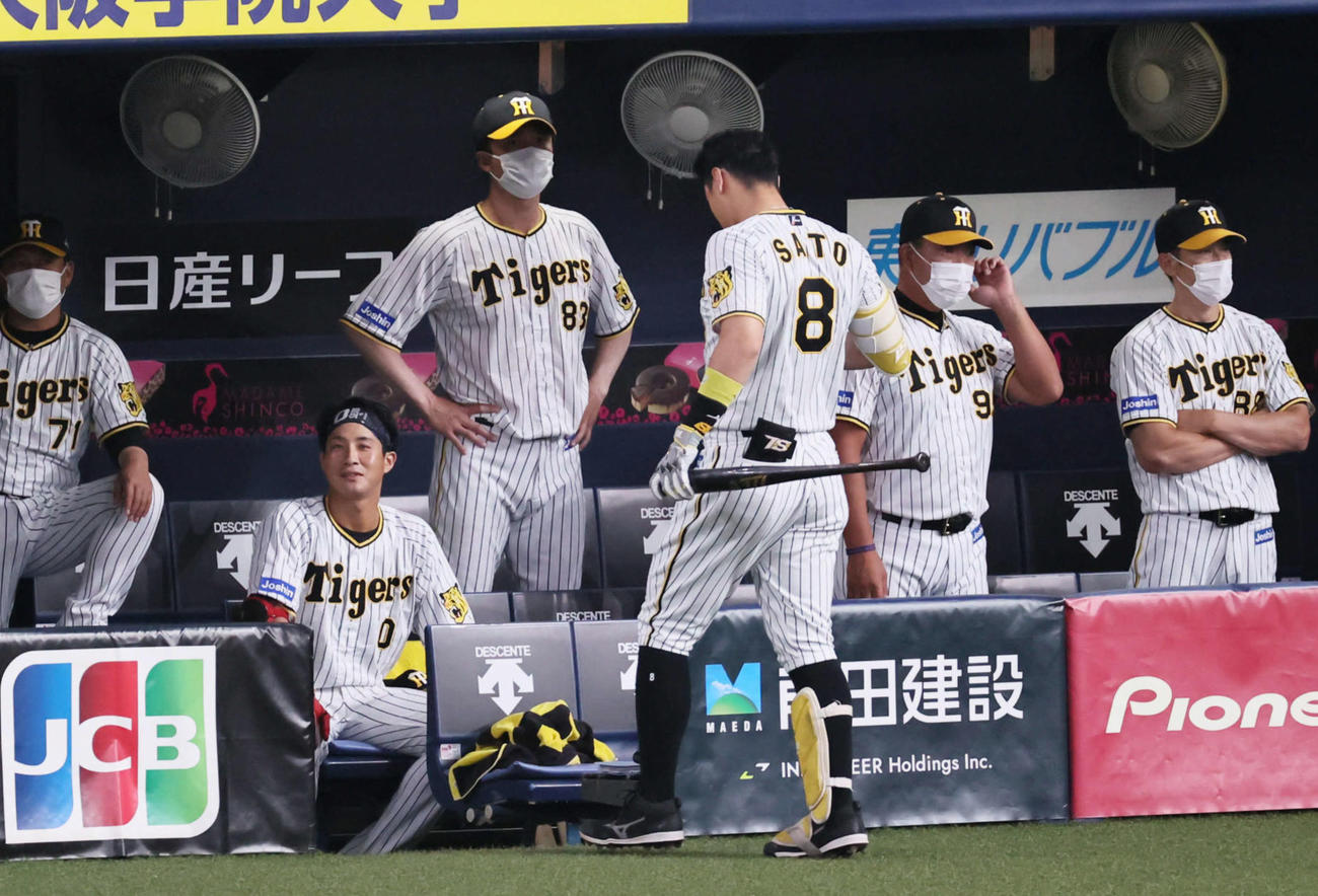 4回裏阪神無死二、三塁、空振り三振に倒れベンチに下がる佐藤輝明。右端は渋い表情の矢野監督（撮影・宮崎幸一）