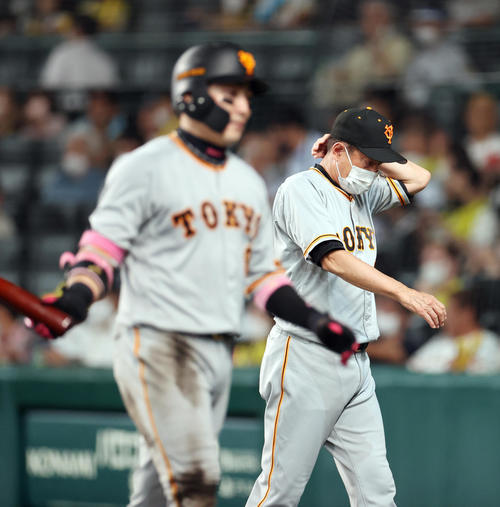阪神対巨人　12回表を終え、頭を抱えながらベンチに戻る原監督。手前は丸（撮影・狩俣裕三）