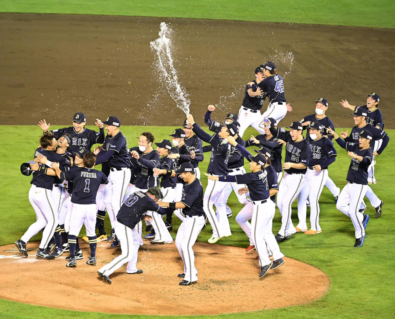 楽天対オリックス　2年連続のパ・リーグ優勝を決め喜びを爆発されるオリックスナイン。中央はペットボトルの水を勢いよく浴びせる山本（撮影・小沢裕）