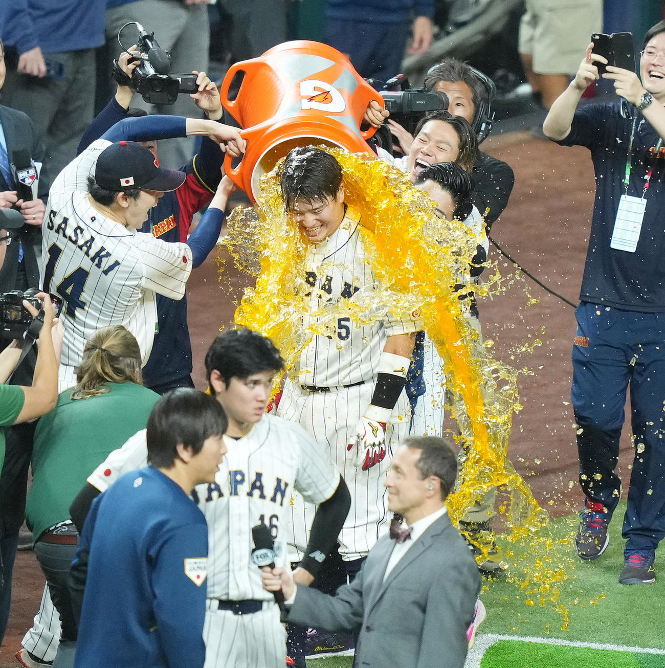 日本対メキシコ　9回、逆転の2点適時二塁打を放ち、佐々木（左）と山本（右）からスポーツドリンクを浴びせられる村上（撮影・菅敏）