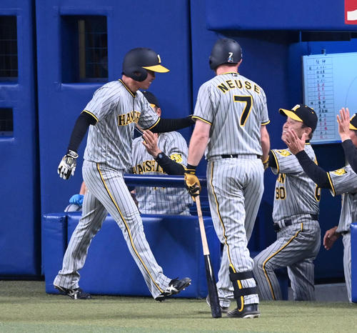 中日対阪神　6回表阪神無死一塁、近本の先制右適時三塁打で生還した村上（左）を笑顔で迎える岡田監督（撮影・前岡正明）