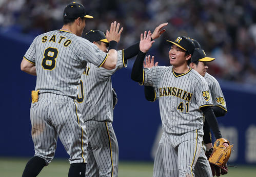 中日対阪神　完封でプロ初勝利を挙げ、笑顔でナインとタッチを交わす村上（右）（撮影・前田充）