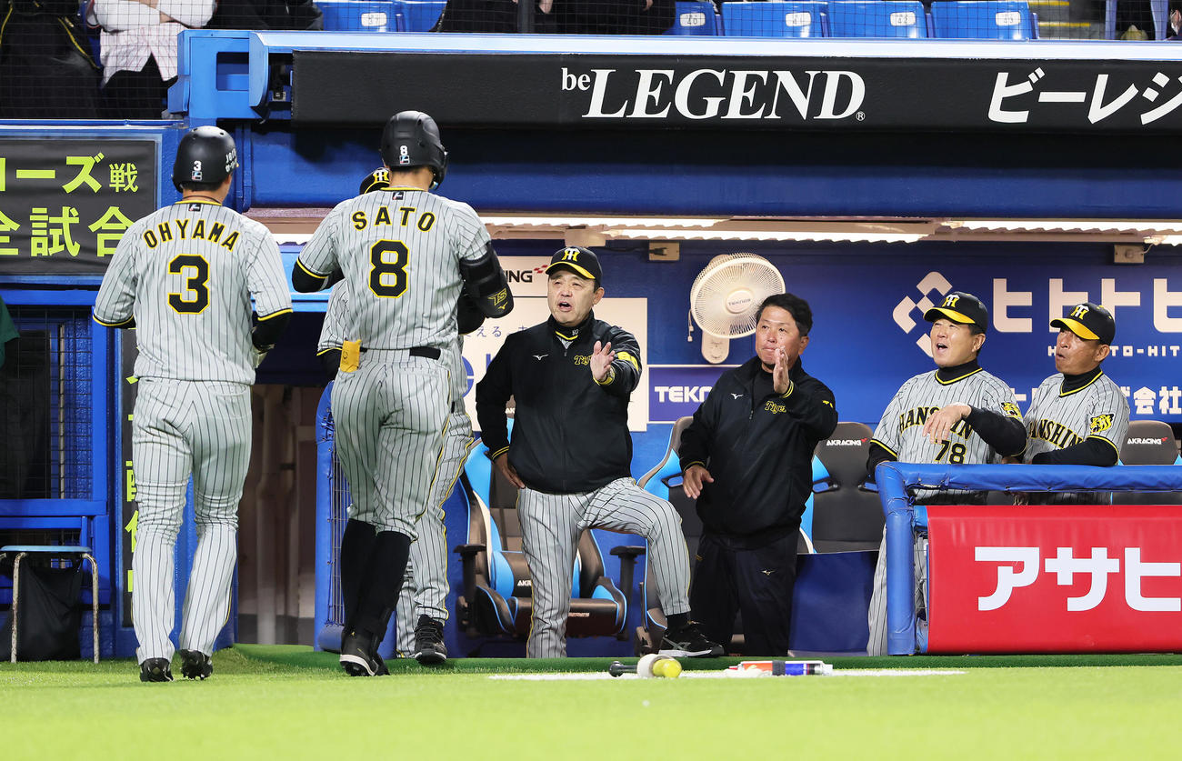 ヤクルト対阪神　8回表阪神無死一塁、右越え2点本塁打を放った佐藤輝（左から2人目）を迎える岡田監督（同3人目）（撮影・足立雅史）