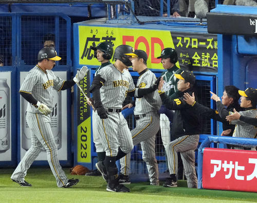 ヤクルト対阪神　8回裏ヤクルト無死一塁、2点本塁打を放った佐藤輝（中央）を迎える岡田監督（右）（撮影・狩俣裕三）