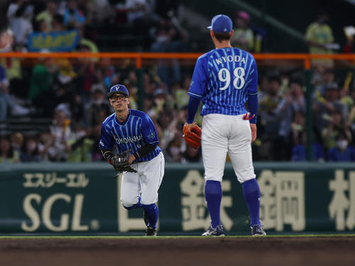 2回裏阪神2死二塁、近本の飛球を捕球できず適時二塁打とした関根。右は京田（撮影・前田充）