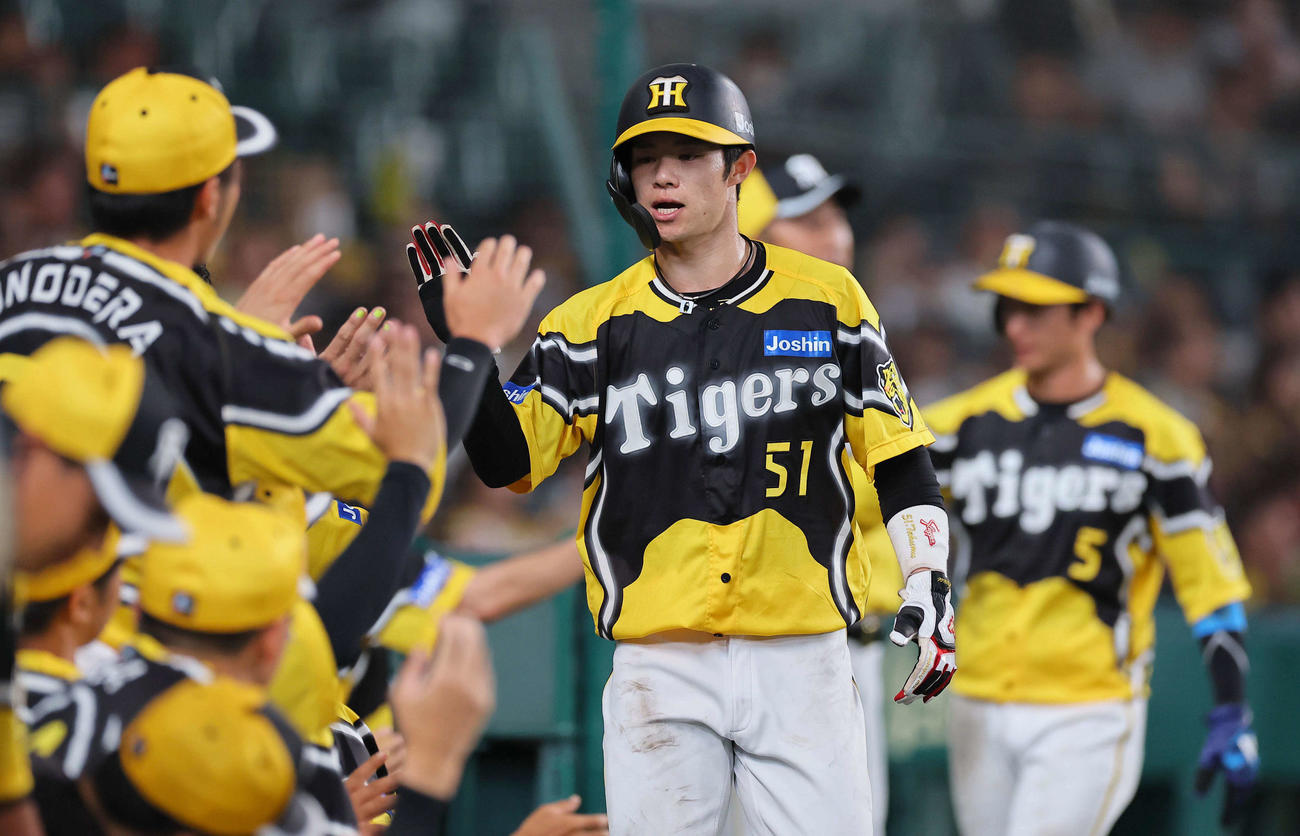 阪神対巨人　7回裏阪神2死二、三塁、森下の左前2点適時打で生還しナインとハイタッチをする中野（中央）と近本（撮影・上田博志）