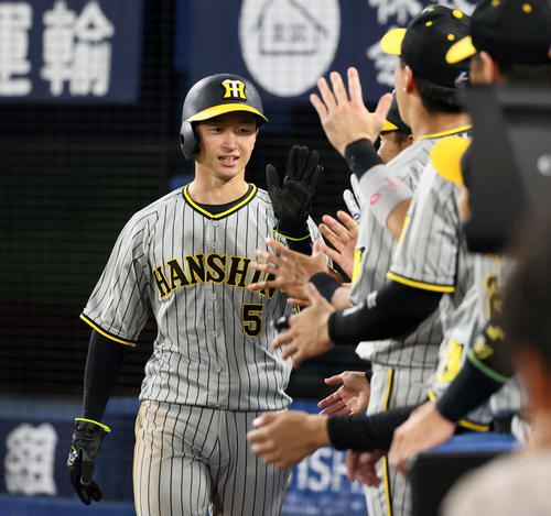 DeNA対阪神　7回表阪神2死一、二塁、近本は森下の中前適時打で生還し、ナインと笑顔でタッチする（撮影・加藤哉）