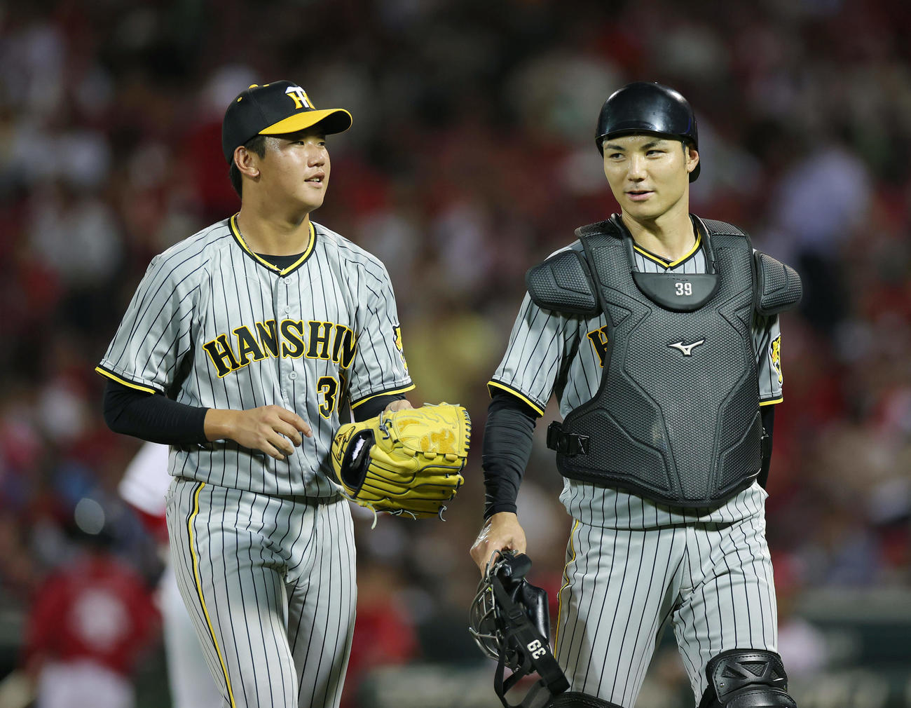 広島対阪神　3回裏を投げ終え、阪神栄枝（右）と言葉を交わしながらベンチへ戻る門別（撮影・前田充）